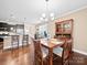 This dining area features a chandelier, wooden table, and hardwood floors, adjacent to the open kitchen and light filled rooms at 5062 Gribble Ln, Lancaster, SC 29720