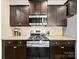 Kitchen featuring stainless steel appliances, granite countertops, dark wood cabinetry, and tile backsplash at 5062 Gribble Ln, Lancaster, SC 29720