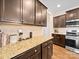 Kitchen featuring stainless steel appliances, granite countertops, dark wood cabinetry, and tile backsplash at 5062 Gribble Ln, Lancaster, SC 29720