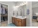 Bathroom featuring double sinks, wood cabinetry, ample counter space, and linen closet at 516 King St, Waxhaw, NC 28173