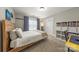 Inviting bedroom featuring neutral carpet, a large window, and a cozy corner with a bookshelf and desk at 516 King St, Waxhaw, NC 28173
