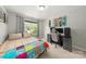 Bright bedroom featuring a work station, neutral walls, a cozy bed with colorful quilt, and ample natural light at 516 King St, Waxhaw, NC 28173