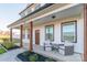 Inviting front porch featuring cozy seating, rustic wood columns, and meticulous landscaping, perfect for relaxing at 5413 Austin Rd # 4, Monroe, NC 28112