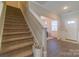 Welcoming hallway features a staircase leading upstairs and a glimpse into the sunlit living area beyond at 5413 Austin Rd # 4, Monroe, NC 28112