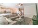 Open-concept living room features a comfortable sectional, ceiling fan, and an open view to the kitchen and staircase at 5413 Austin Rd # 4, Monroe, NC 28112
