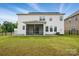 Backyard view of a home with a screened porch and well-maintained grassy lawn at 6416 Willow Pin Ln, Huntersville, NC 28078
