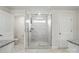 Bathroom featuring marble-tiled shower with glass enclosure and a window at 6416 Willow Pin Ln, Huntersville, NC 28078