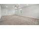 Spacious bedroom with plush carpet, ceiling fan, and abundant natural light through large windows at 6416 Willow Pin Ln, Huntersville, NC 28078