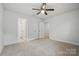 Bedroom with neutral carpet, a ceiling fan, and multiple closets/doorways at 6416 Willow Pin Ln, Huntersville, NC 28078