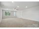 Bright bedroom features neutral walls, carpeted flooring, ceiling fan, and natural light from large windows at 6416 Willow Pin Ln, Huntersville, NC 28078