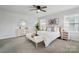 Bright bedroom with plush carpet, fan, large windows, and light neutral furniture at 6416 Willow Pin Ln, Huntersville, NC 28078