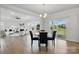 Open-concept dining area with wood floors, modern lighting, and an open view to the living room at 6416 Willow Pin Ln, Huntersville, NC 28078
