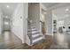 Hallway with wainscotting, light gray stairs, and luxury vinyl plank flooring at 6416 Willow Pin Ln, Huntersville, NC 28078