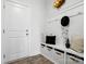 Bright mudroom with white wainscotting, built in bench, decorative gold sculpture, and door to the exterior at 6416 Willow Pin Ln, Huntersville, NC 28078