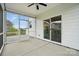 Covered porch with an outdoor ceiling fan, stone-tile flooring, and views of an enclosed yard at 6416 Willow Pin Ln, Huntersville, NC 28078