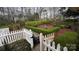 Lush garden with manicured hedges, walkway, black metal fencing, and a white picket fence at 700 Valleyview Dr # 1, Albemarle, NC 28001