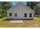 A house with a white vinyl siding and a concrete patio sits in a dry, green backyard at 706 Live Oak St, Shelby, NC 28150