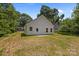 A house with a white vinyl siding and a dry, green backyard with plenty of space at 706 Live Oak St, Shelby, NC 28150