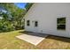 A house with a white vinyl siding and a concrete patio sits in a dry, green backyard at 706 Live Oak St, Shelby, NC 28150