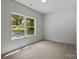 A bright bedroom features plush carpeting and a window offering natural light at 706 Live Oak St, Shelby, NC 28150