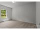 A bright bedroom features plush carpeting and a window offering natural light at 706 Live Oak St, Shelby, NC 28150