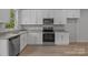 Modern kitchen features white cabinets, stainless steel appliances and light wood flooring at 706 Live Oak St, Shelby, NC 28150