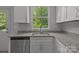 Well-lit kitchen sink featuring granite countertops, a stainless steel dishwasher, and a view from the window at 706 Live Oak St, Shelby, NC 28150