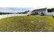 Expansive backyard featuring a privacy fence, manicured lawn, patio area, fire pit, and lush surrounding greenery at 7315 Amberly Hills Rd, Charlotte, NC 28215
