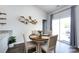 Bright dining area featuring a wood table, modern accents, and sliding glass doors to the outdoor patio at 7315 Amberly Hills Rd, Charlotte, NC 28215