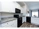 Modern kitchen with white cabinets, granite countertops, black appliances, and an open layout at 7315 Amberly Hills Rd, Charlotte, NC 28215