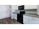 Well-equipped kitchen with white cabinets, granite countertops, black appliances, and wood-look flooring at 7315 Amberly Hills Rd, Charlotte, NC 28215