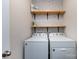 Functional laundry room featuring a side-by-side washer and dryer with shelving above at 7315 Amberly Hills Rd, Charlotte, NC 28215