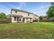 Large backyard with a stone fire pit, patio dining set, and lush green lawn at 8381 Chatsworth Dr, Indian Land, SC 29707
