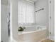 Bright bathroom featuring a soaking tub with striped curtains and a separate glass enclosed shower at 8381 Chatsworth Dr, Indian Land, SC 29707