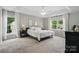 Spacious main bedroom with tray ceilings, two windows and neutral color palette at 8381 Chatsworth Dr, Indian Land, SC 29707