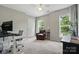 Well-lit home office with a modern desk, comfortable chair, and a view of the outdoors at 8381 Chatsworth Dr, Indian Land, SC 29707