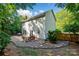 Exterior of home featuring a stone patio with outdoor seating, mature trees, and a fenced yard at 8744 Barrister Way, Charlotte, NC 28216