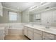 Well-lit bathroom boasts a soaking tub, double vanity, and tiled flooring, ideal for relaxation at 8744 Barrister Way, Charlotte, NC 28216