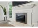 Close up on the fireplace with hardwood floors and a large window at 8744 Barrister Way, Charlotte, NC 28216