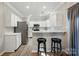 Bright kitchen featuring white cabinetry, stainless appliances and bar seating at 8744 Barrister Way, Charlotte, NC 28216