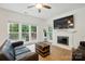 Bright living room featuring hardwood floors, a fireplace with white mantel, and large windows offering backyard views at 8744 Barrister Way, Charlotte, NC 28216