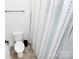 Clean bathroom featuring a toilet, towel rack, and shower with patterned curtain at 8916 Inverness Bay Rd, Charlotte, NC 28278