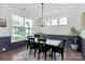 Bright dining room featuring classic wainscoting, a modern chandelier, and large windows at 8916 Inverness Bay Rd, Charlotte, NC 28278
