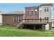 Well-maintained backyard features a lush lawn, wooden deck and brick exterior, perfect for relaxation at 9034 Kensington Forest Dr, Harrisburg, NC 28075