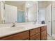 Bathroom with double vanity, warm wood cabinets, and a framed mirror at 9034 Kensington Forest Dr, Harrisburg, NC 28075