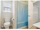 Bright bathroom featuring a toilet, bathtub with curtain, and neutral tile floor at 9034 Kensington Forest Dr, Harrisburg, NC 28075