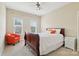 Cozy bedroom with a wooden bed frame, a bright orange chair, and natural light from two windows at 9034 Kensington Forest Dr, Harrisburg, NC 28075