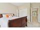 A bedroom featuring a wooden bed frame, closet, and view to the hallway with natural light at 9034 Kensington Forest Dr, Harrisburg, NC 28075
