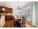 Bright dining area with hardwood floors, large windows, and a view into the kitchen at 9034 Kensington Forest Dr, Harrisburg, NC 28075