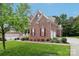 Beautiful brick home with lush green lawn, colorful flowerbeds, and a two car garage at 9034 Kensington Forest Dr, Harrisburg, NC 28075